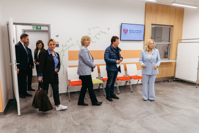 Grupa uczestników spotkania zwiedza nowo otwartą przychodnię.