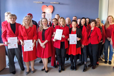 Dyrekcja i pracownicy ubrani na czerwono na tle logo SPZZLO Warszawa Żoliborz-Bielany.